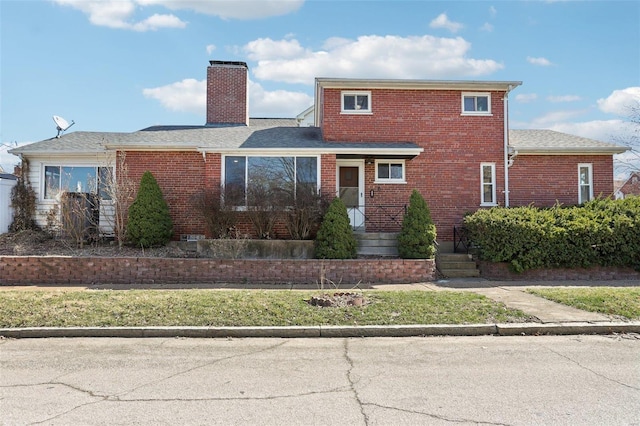 traditional-style home featuring brick siding and a chimney