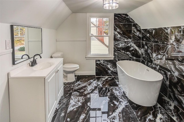 bathroom with tile walls, a tub to relax in, lofted ceiling, and toilet