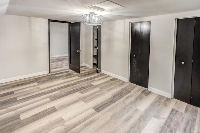 unfurnished bedroom with two closets and light hardwood / wood-style flooring