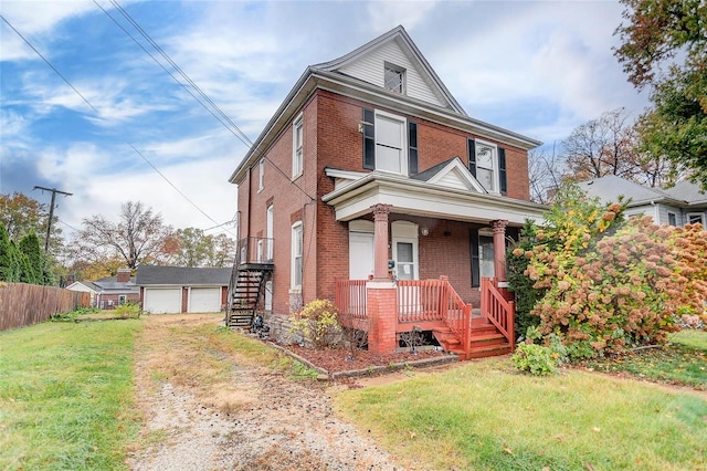 view of front of house featuring an outbuilding, a garage, covered porch, and a front lawn