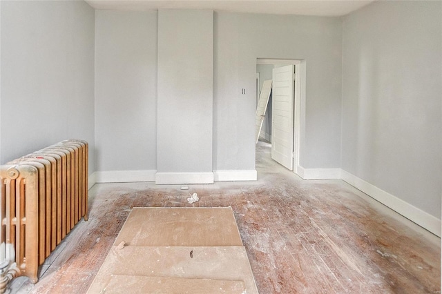 unfurnished room featuring radiator and wood-type flooring