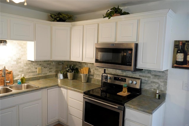 kitchen featuring backsplash, white cabinetry, sink, and stainless steel appliances