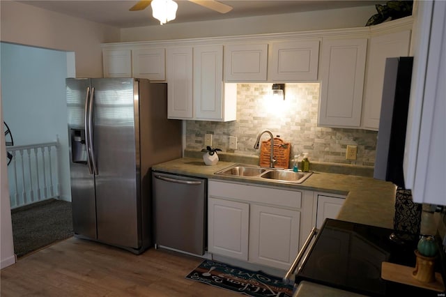 kitchen with sink, light hardwood / wood-style flooring, ceiling fan, appliances with stainless steel finishes, and white cabinetry