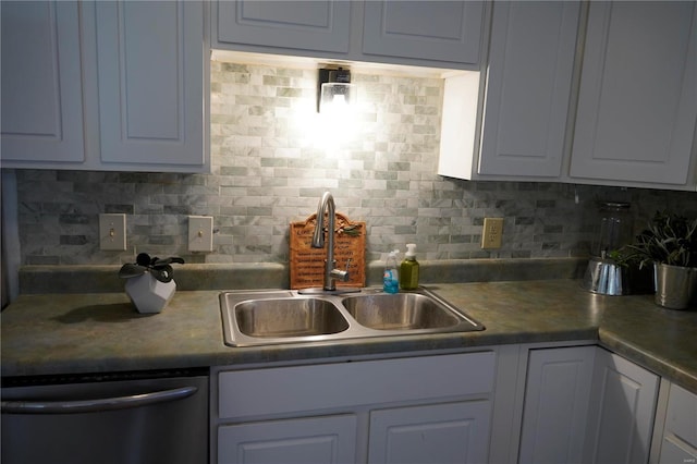 kitchen featuring white cabinets, dishwasher, sink, and tasteful backsplash