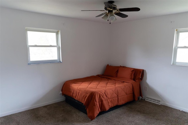 bedroom featuring multiple windows, ceiling fan, and carpet floors