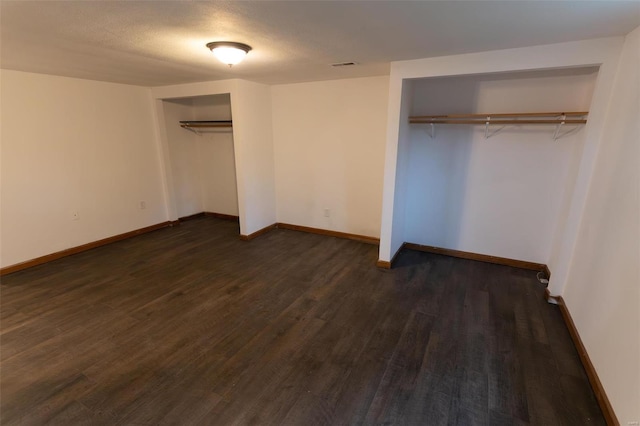 unfurnished bedroom featuring a textured ceiling and dark hardwood / wood-style flooring