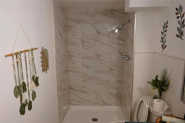 bathroom featuring a tile shower and toilet