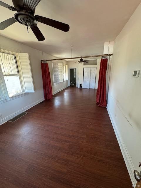 empty room with dark wood-type flooring and ceiling fan