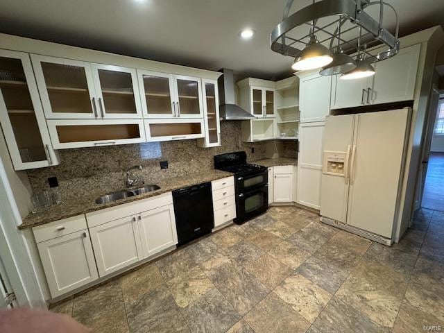 kitchen featuring wall chimney range hood, dark stone counters, sink, black appliances, and tasteful backsplash