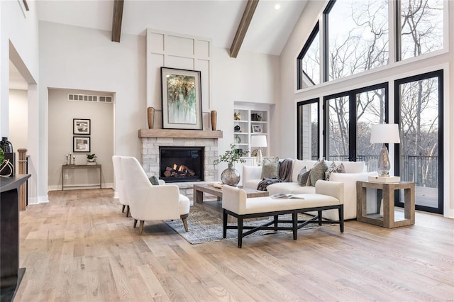 living room featuring light hardwood / wood-style floors, a fireplace, and a wealth of natural light