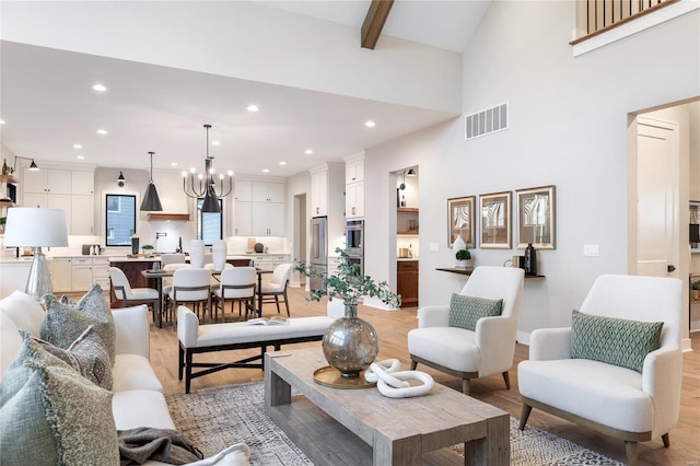 living room with beamed ceiling, light hardwood / wood-style floors, high vaulted ceiling, and a chandelier