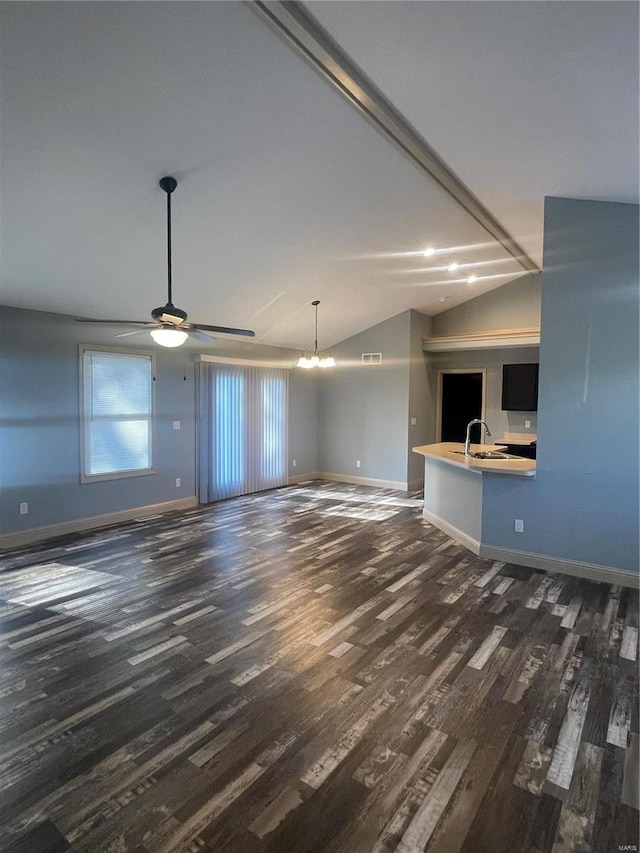 unfurnished living room with vaulted ceiling, ceiling fan with notable chandelier, sink, and dark hardwood / wood-style floors