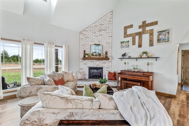 living room featuring a fireplace, light hardwood / wood-style floors, and high vaulted ceiling