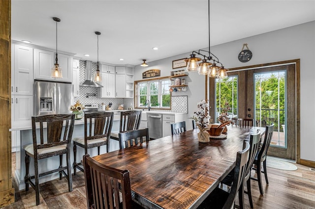 dining space featuring dark wood-type flooring, a wealth of natural light, and french doors