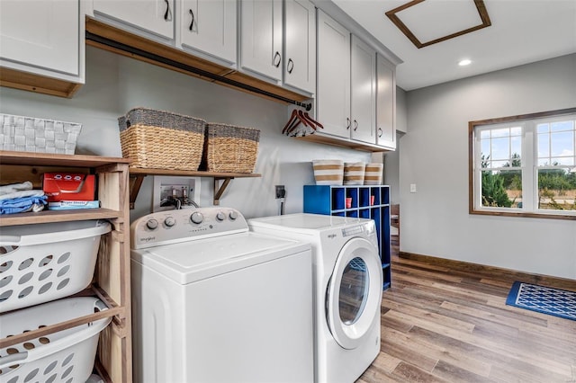 washroom featuring light hardwood / wood-style floors, cabinets, and independent washer and dryer