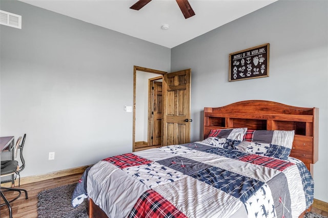 bedroom with hardwood / wood-style flooring, ceiling fan, and vaulted ceiling