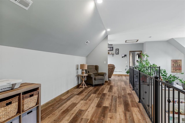 living area featuring wood-type flooring and vaulted ceiling