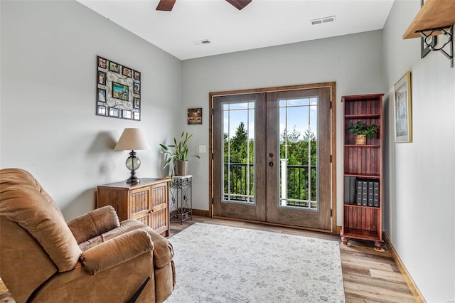 sitting room featuring french doors, ceiling fan, and light hardwood / wood-style flooring