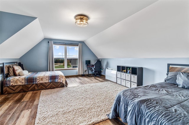 bedroom featuring lofted ceiling and hardwood / wood-style floors