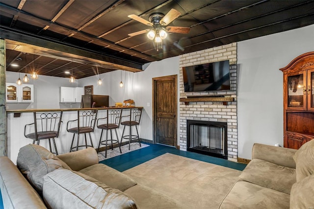 living room with indoor bar, ceiling fan, and a brick fireplace