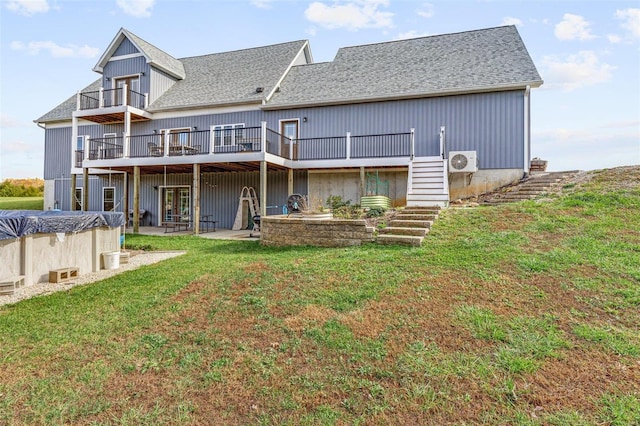 rear view of property with a wooden deck, ac unit, a lawn, and a patio