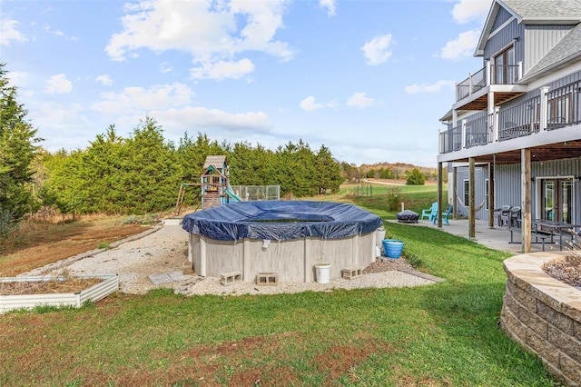 view of pool featuring a wooden deck, a patio, and a yard