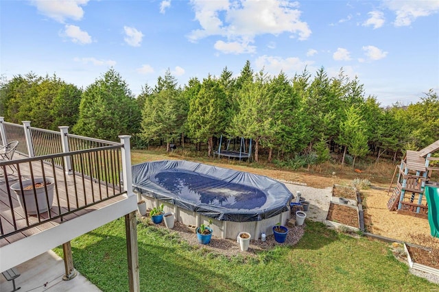 view of pool featuring a lawn and a wooden deck