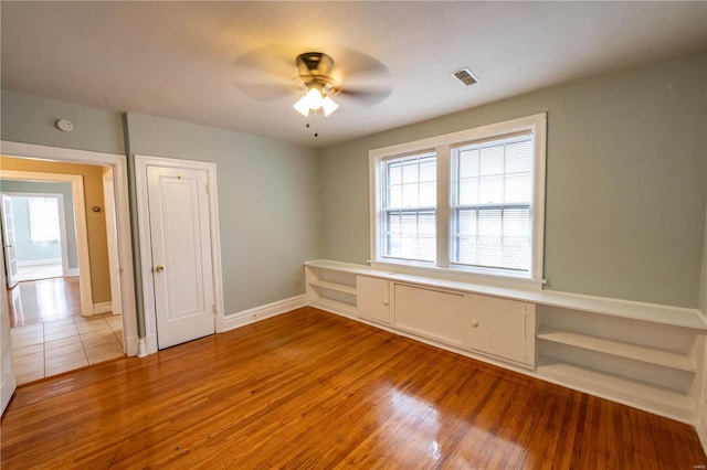 empty room with light wood-type flooring and ceiling fan