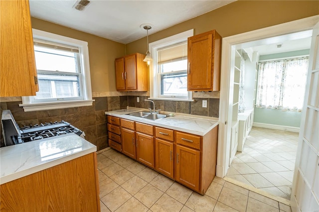 kitchen with light tile patterned floors, a healthy amount of sunlight, pendant lighting, and sink