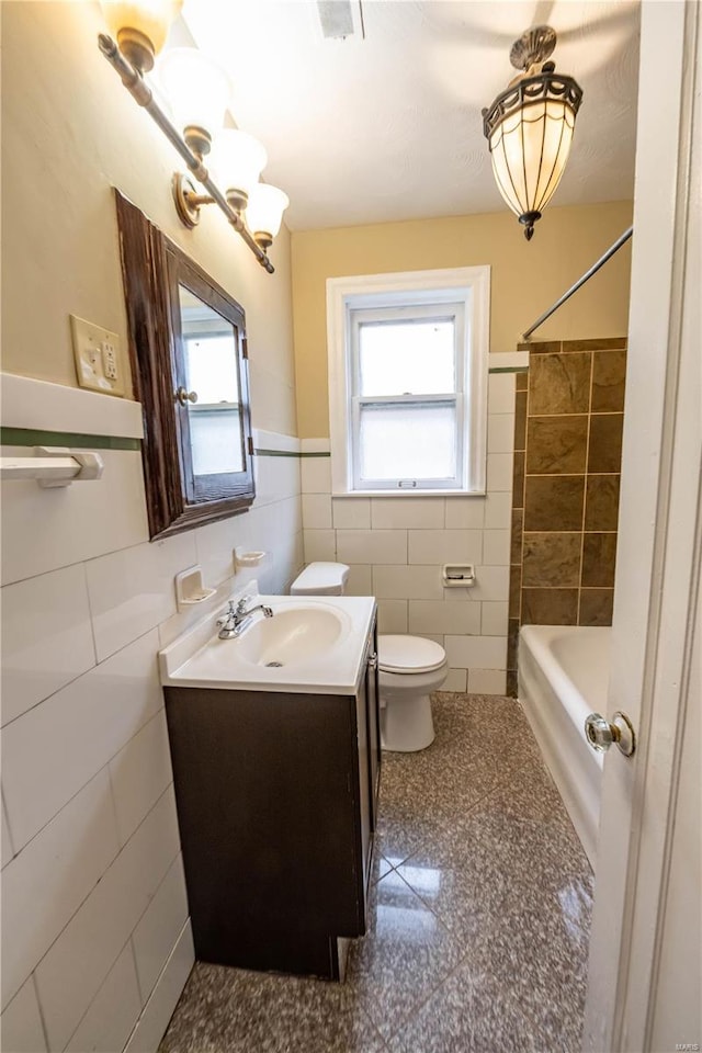 full bathroom featuring  shower combination, vanity, tile walls, and toilet