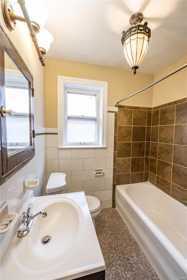 full bathroom with toilet, tile walls, and a wealth of natural light