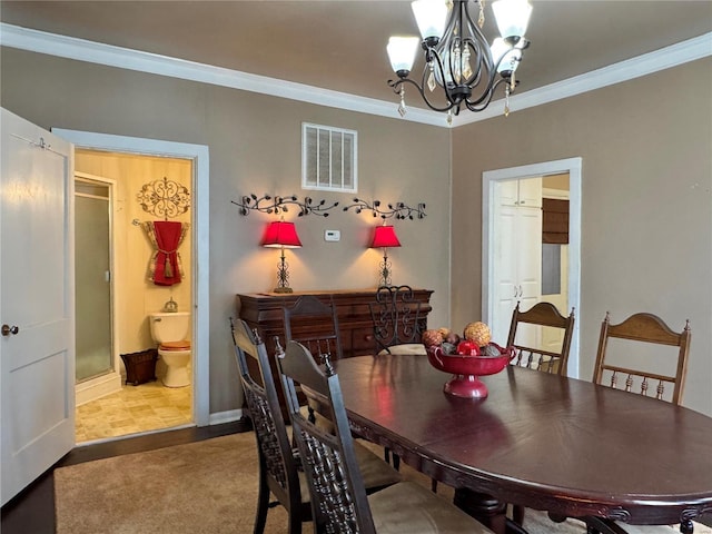 dining room featuring a chandelier, ornamental molding, carpet, and visible vents