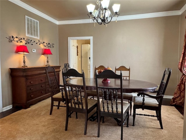 dining space with visible vents, a chandelier, and crown molding