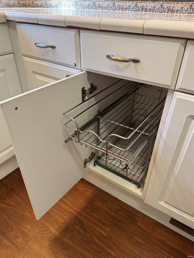 room details with dark wood-style floors, white cabinetry, and light countertops