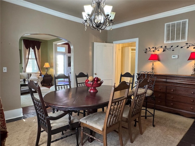 dining area with visible vents, arched walkways, ornamental molding, carpet flooring, and a chandelier