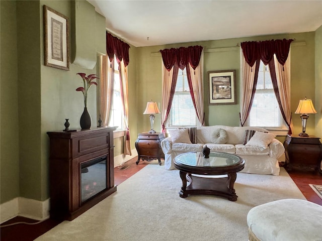 sitting room with a glass covered fireplace and carpet flooring