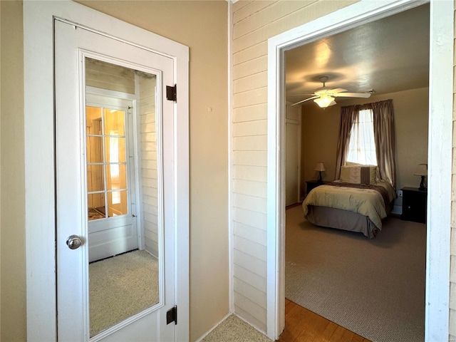 bedroom featuring wooden walls and a ceiling fan