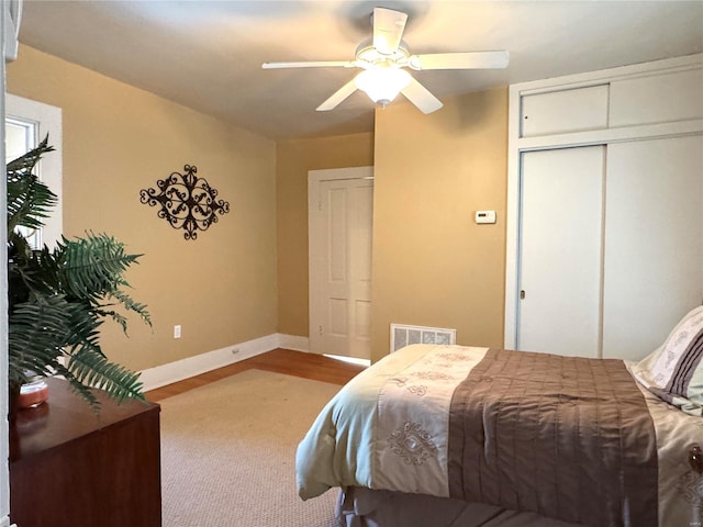 bedroom with baseboards, visible vents, ceiling fan, and a closet