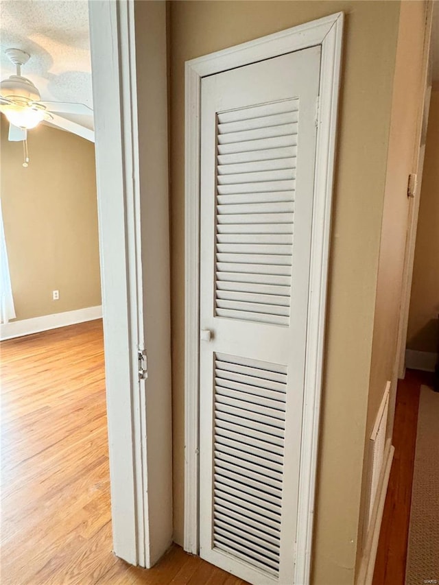 room details featuring baseboards, a ceiling fan, and wood finished floors