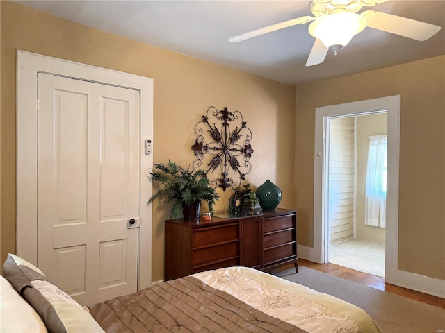 bedroom with ceiling fan, baseboards, and wood finished floors