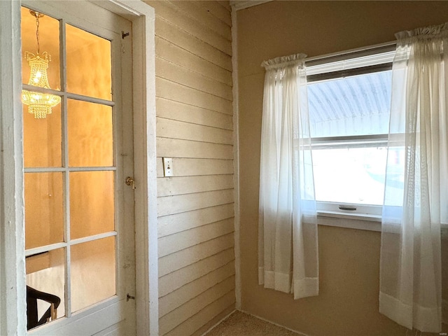 doorway to outside featuring wood walls