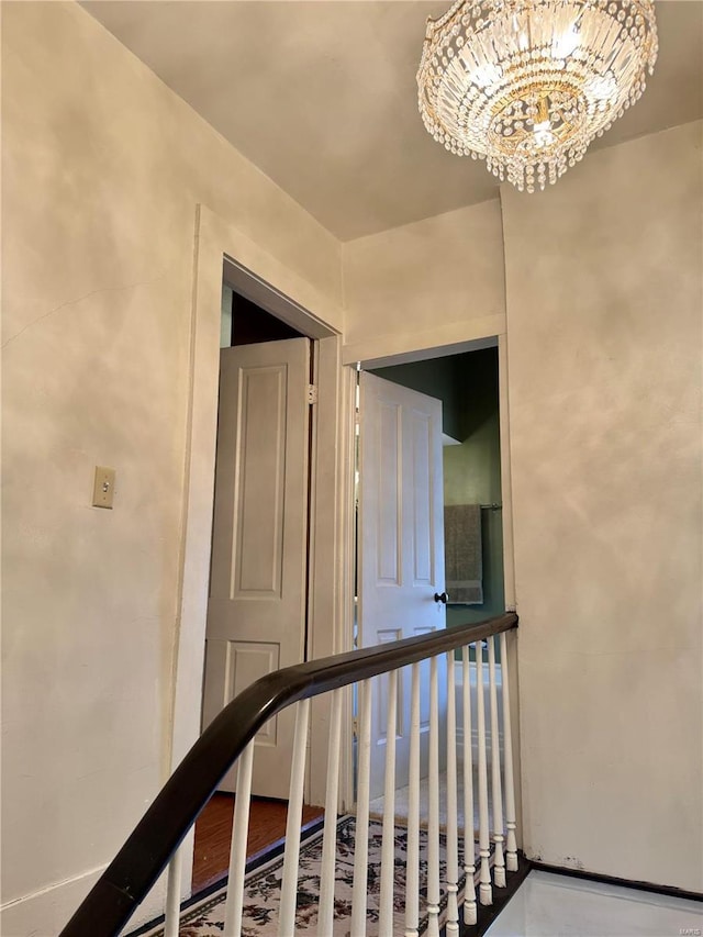 stairway featuring an inviting chandelier