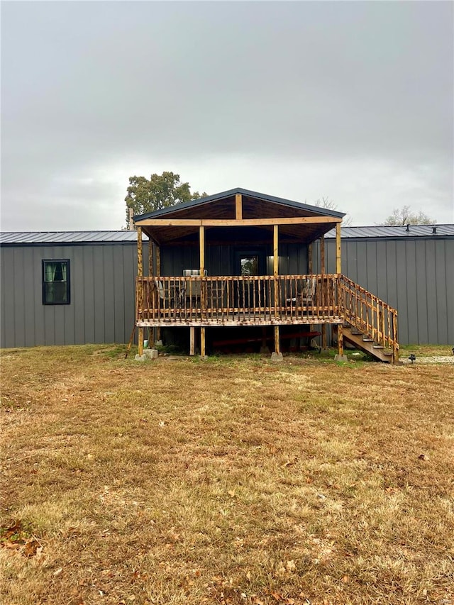 rear view of house featuring a yard and a deck