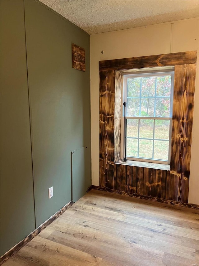 empty room featuring a textured ceiling and light wood-type flooring