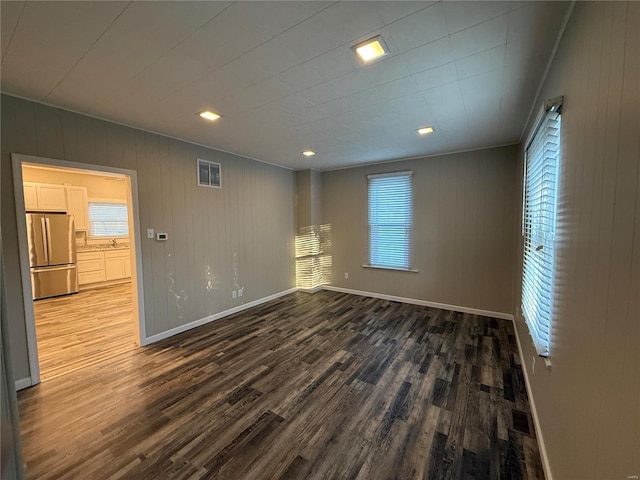 empty room featuring hardwood / wood-style floors and wooden walls