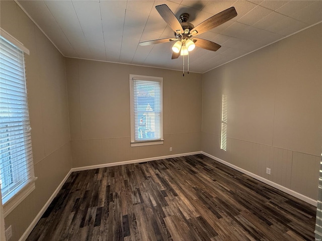 empty room with ornamental molding, dark hardwood / wood-style flooring, and ceiling fan