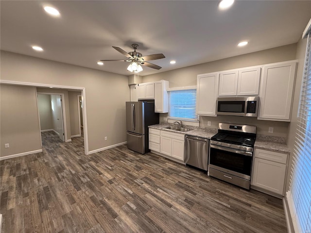 kitchen featuring white cabinets, sink, light stone counters, and appliances with stainless steel finishes