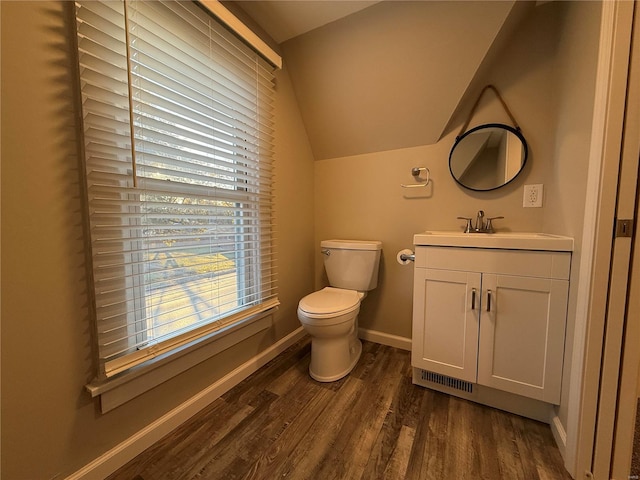 bathroom featuring wood-type flooring, vanity, toilet, and lofted ceiling