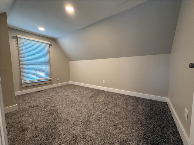 bonus room with carpet flooring and vaulted ceiling