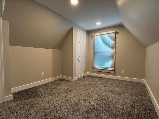 bonus room with vaulted ceiling and dark carpet